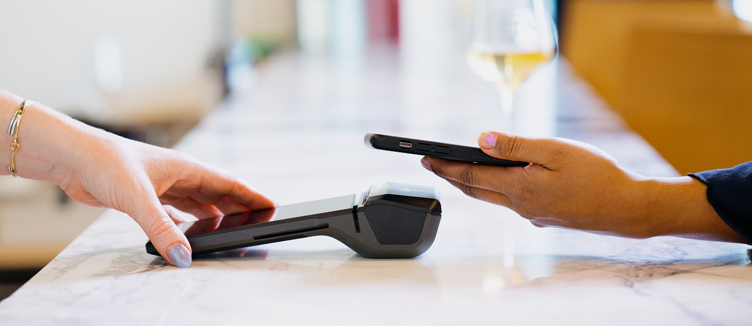 A guest paying by contactless at a hospitality counter